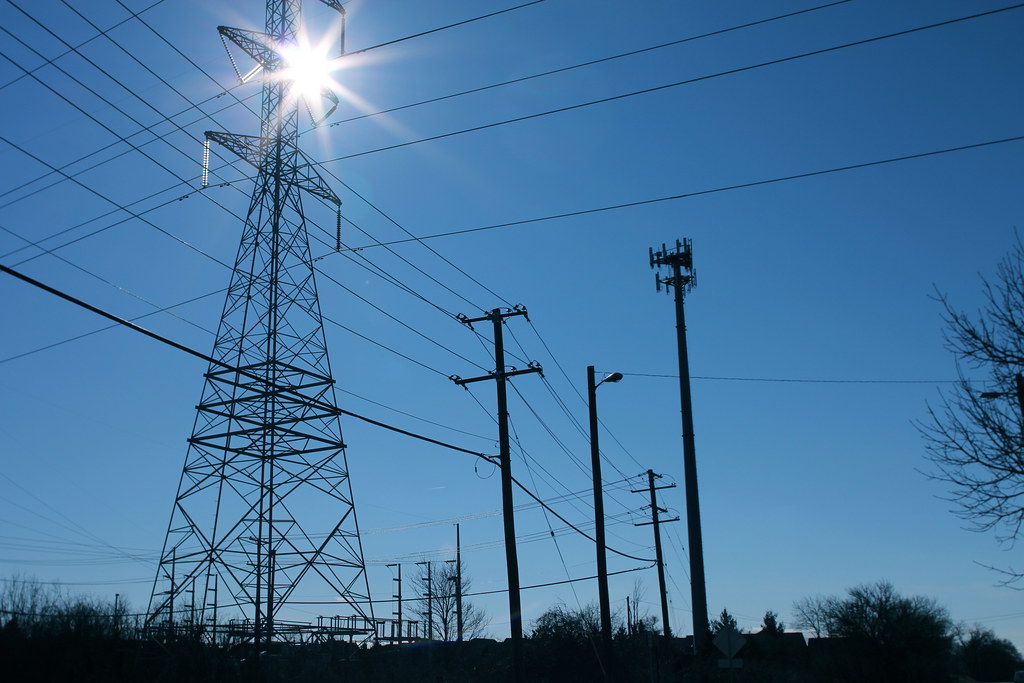 Electricity transmission towers at night — the always-on energy demand of AI data centers